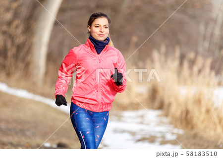 Young girl on trail running training in winter Young girl on trail running training in winter 58183510