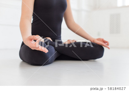 Beautifull woman in black sport outfit sits on white bare floor. Selective focus 58184027
