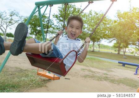 Child playing funny on outdoor playground in the Child playing funny on outdoor playground in the 58184857