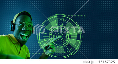 Young african-american man's touching virtual reality in neon light Young african-american man's touching virtual reality in neon light 58187325