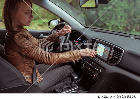 Woman girl car interior leather jacket in autumn and spring, in forest park, chooses navigation Woman girl car interior leather jacket in autumn and spring, in forest park, chooses navigation 58189356
