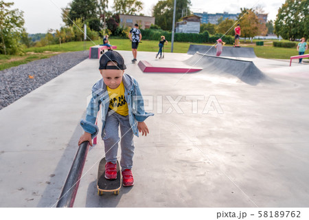 Playground children play skate, little boy 3-5 years old, learning skate, scooter board skateboard 58189762
