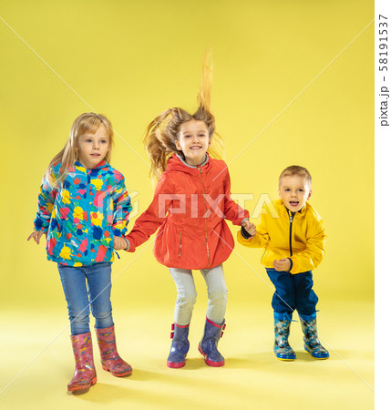 A full length portrait of a bright fashionable kids in a raincoat A full length portrait of a bright fashionable kids in a raincoat 58191537