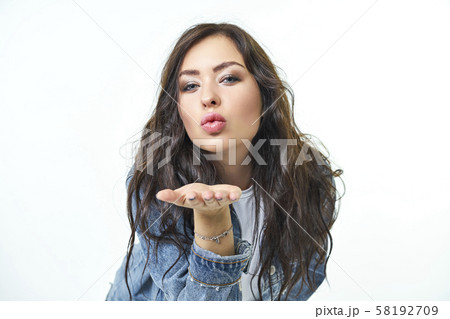 Portrait of a cute beautiful girl. Sends blows a kiss while looking at the camera, Sexy female lips Portrait of a cute beautiful girl. Sends blows a kiss while looking at the camera, Sexy female lips 58192709