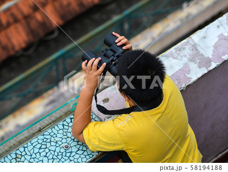 An Asian boy using the binocular 58194188
