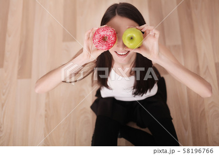 Diet. Woman Measuring Body Weight On Weighing Scale Holding Donut and apple. Sweets Are Unhealthy Diet. Woman Measuring Body Weight On Weighing Scale Holding Donut and apple. Sweets Are Unhealthy 58196766