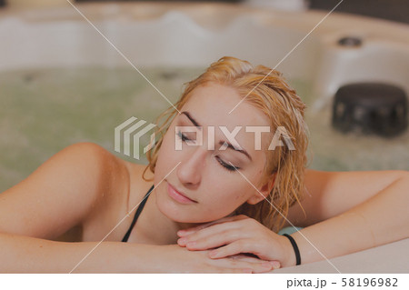 Young beautiful woman relaxes in a jacuzzi. Young beautiful woman relaxes in a jacuzzi. 58196982