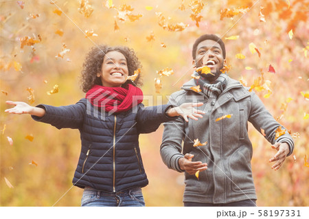 Happy afro couple throwing autumn fall leaves Happy afro couple throwing autumn fall leaves 58197331