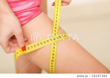 Fit, healthy and sporty woman in swimsuit. Beautiful girl measuring her body. Sport, fitness, diet 58197364