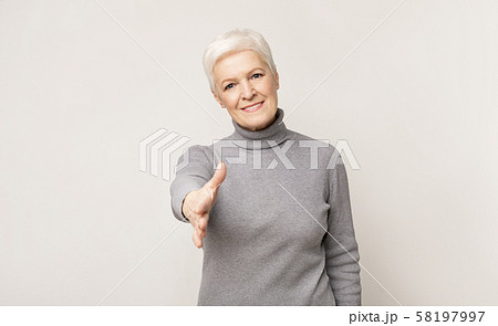 Elderly woman extending hand for handshake on camera 58197997