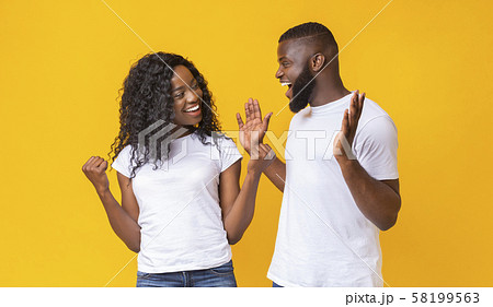Black man and woman happily surprised with good news 58199563