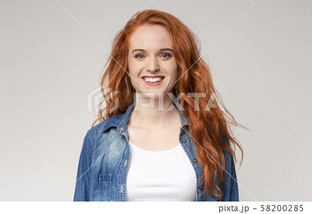 Portrait of beautiful redhead girl smiling to camera Portrait of beautiful redhead girl smiling to camera 58200285