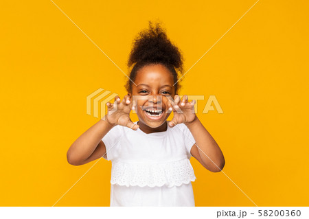 Cute playful little african girl is showing claws like tiger 58200360