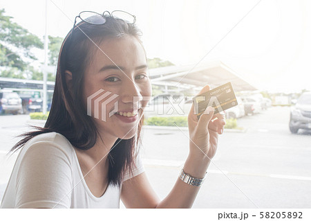 Smiling asian young female model holding up credit Smiling asian young female model holding up credit 58205892