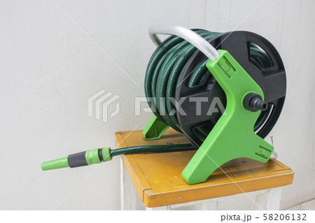 Nozzle of gardening water hose on concrete 58206132