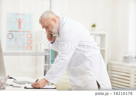 Doctor using phone in his work Doctor using phone in his work 58210176