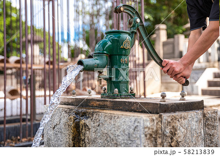 手押しポンプで井戸の水を汲む 58213839