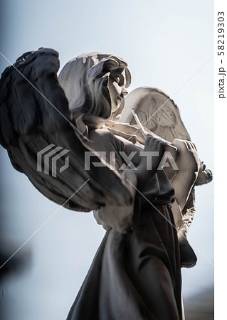 Statue of an angel playing violin in the garden 58219303