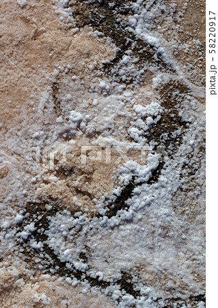 Natural white salt crystal texture on the sand, macro, close up.  58220917