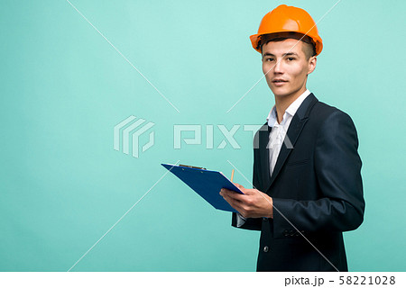A young professional wearing a hard hat and A young professional wearing a hard hat and 58221028