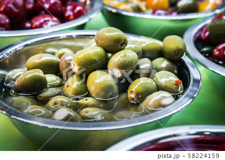 marinated and stuffed olives are on display in a store marinated and stuffed olives are on display in a store 58224159