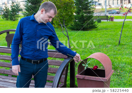 A sad man did not wait for his beloved and in desperation threw the rose into the trash 58225440