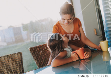 Delighted pleasant woman having a pleasant time with her daughter at home Delighted pleasant woman having a pleasant time with her daughter at home 58225510