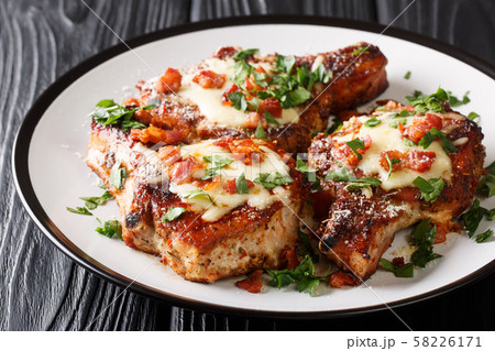 Tasty pork chops with melted parmesan and bacon 58226171