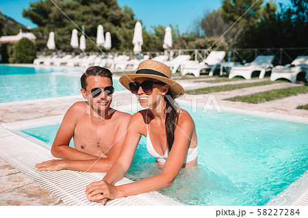 Cheerful couple resting in a swimming pool 58227284