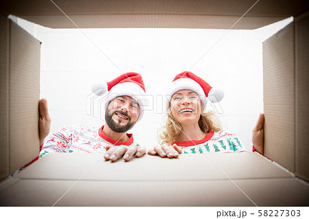 Surprised couple unpack Christmas gift box Surprised couple unpack Christmas gift box 58227303