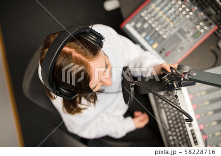 Directly Above Shot Of Radio Jockey Using Microphone And Headpho 58228716