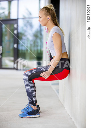 Young Woman Exercising Muscle Strength Against Wall Young Woman Exercising Muscle Strength Against Wall 58230293