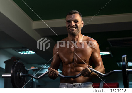 muscular bodybuilder doing exercise on bars in the gym muscular bodybuilder doing exercise on bars in the gym 58230584