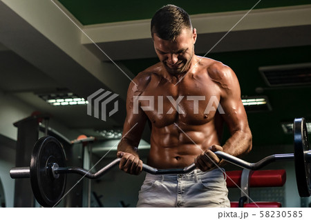 muscular bodybuilder doing exercise on bars in the gym muscular bodybuilder doing exercise on bars in the gym 58230585