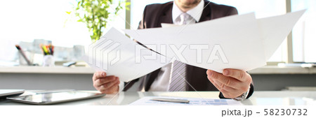 Male arm hold papers at office workplace closeup 58230732
