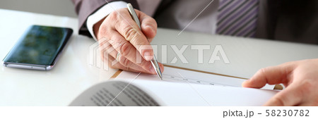 Male arm in suit and tie fill form clipped to pad Male arm in suit and tie fill form clipped to pad 58230782
