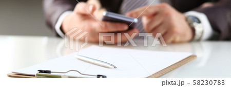 Silver pen lie at paper clipped to pad on table Silver pen lie at paper clipped to pad on table 58230783