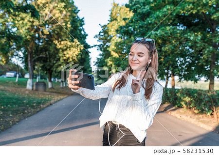 teenager girl 12-15 years old, summer city park fall, photographs herself on phone, video call teenager girl 12-15 years old, summer city park fall, photographs herself on phone, video call 58231530