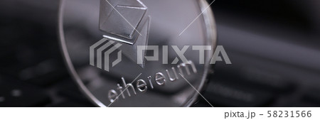 Silver ethereum coin is lying on laptop 58231566