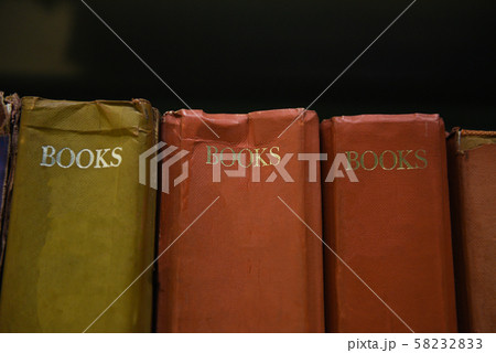 Old books on the bookshelf in the library - 58232833