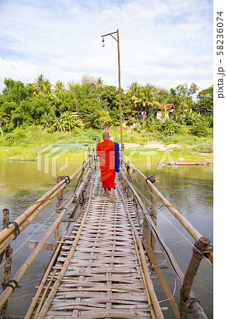 ルアンパバーン　バンブーブリッジを渡る僧侶 58236074