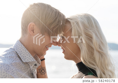 Flirting couple in romantic embrace on beach at summer 58240178