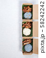 Sticky rice with grilled pork and fried pork put in a brown paper box 58242242