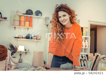 Positive delighted woman leaning on her workplace 58242421