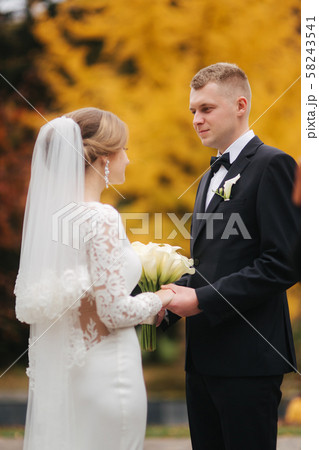 Beautiful autumn in the park. Just married couple walking by the big yellow tree 58243541