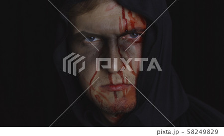 Man executioner Halloween makeup and costume. Guy with blood on his face 58249829