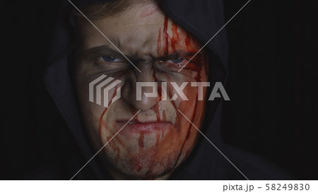 Man executioner Halloween makeup and costume. Guy with blood on his face 58249830