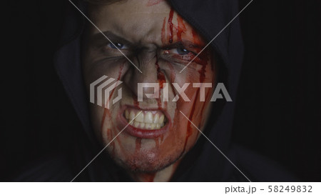 Man executioner Halloween makeup and costume. Guy with blood on his face 58249832
