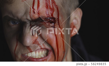 Halloween man portrait. Guy with dripping blood on his face. Scary makeup 58249835