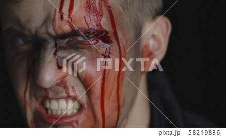 Halloween man portrait. Guy with dripping blood on his face. Scary makeup Halloween man portrait. Guy with dripping blood on his face. Scary makeup 58249836